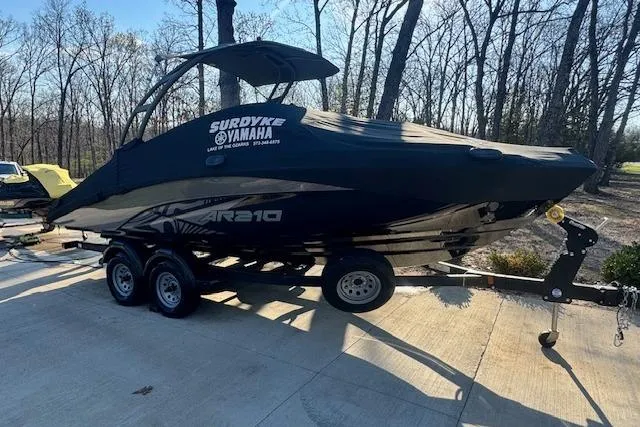 Slide: The Image of 2021 Yamaha AR 210 boat on trailer, covered, parked outdoors in wooded area. - 7