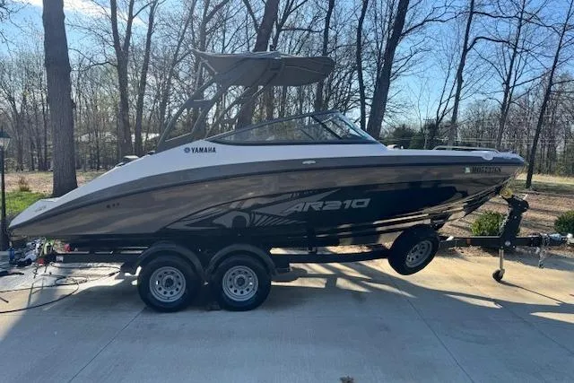 Slide: The Image of 2021 Yamaha AR 210 boat on trailer in wooded area. - 8