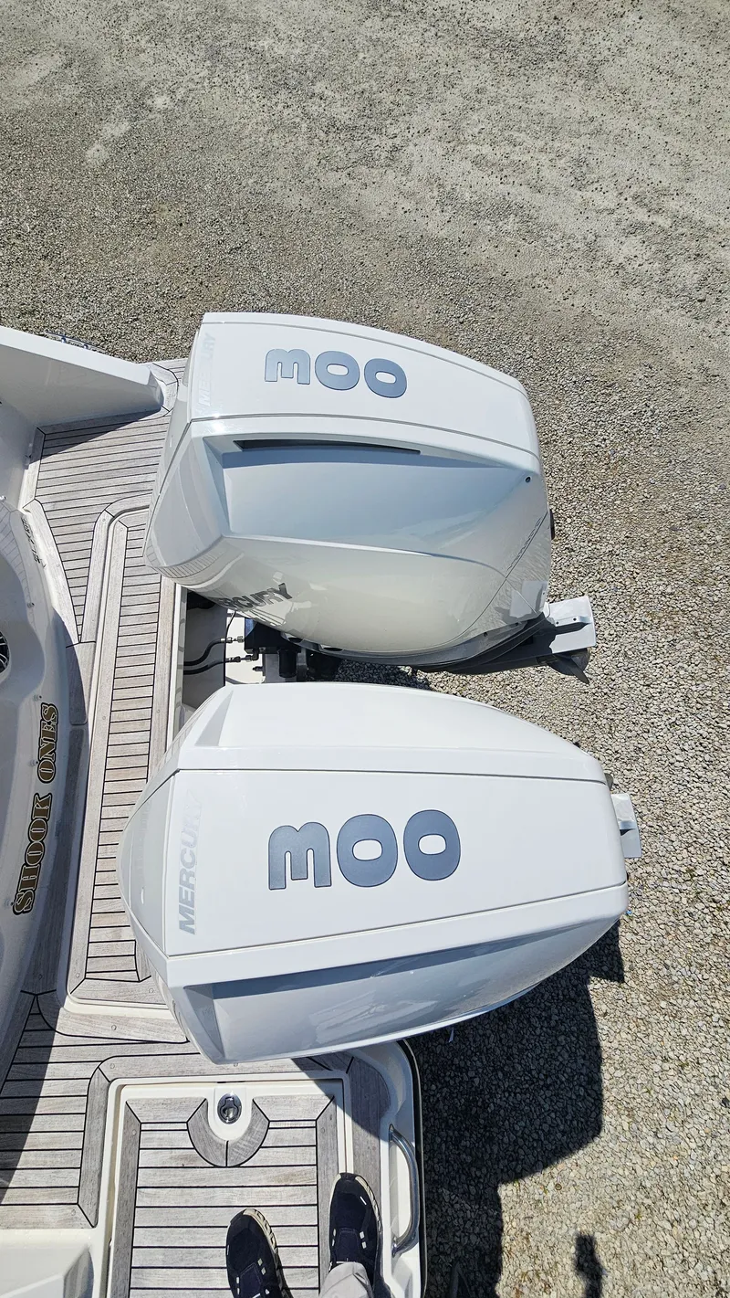 Slide: The Image of 2023 Sea Ray SLX 310 Outboard with twin engines on gravel surface. - 10