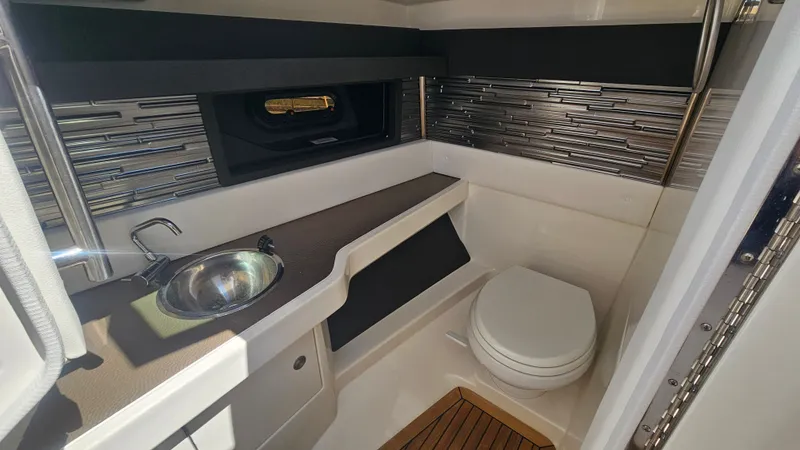 Slide: The Image of Interior of 2023 Sea Ray SLX 310 Outboard with toilet and sink. - 33