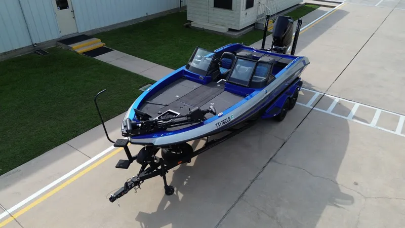 Slide: The Image of 2025 Vexus DVX22S boat on trailer, blue, parked in a yard. - 11