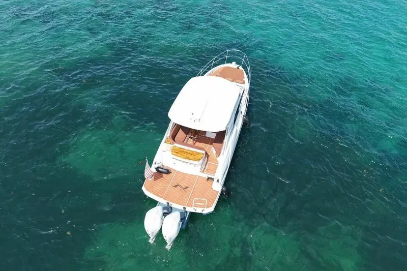 Slide: The Image of Aerial view of 2025 NX Boats 340 Sport Coupe on clear turquoise water. - 13