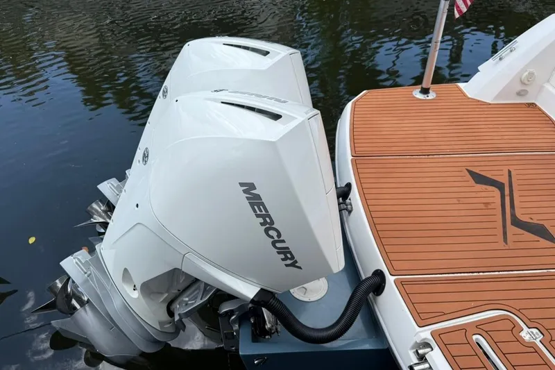 Slide: The Image of 2025 NX Boats 340 Sport Coupe with dual Mercury outboard engines on teak deck. - 15