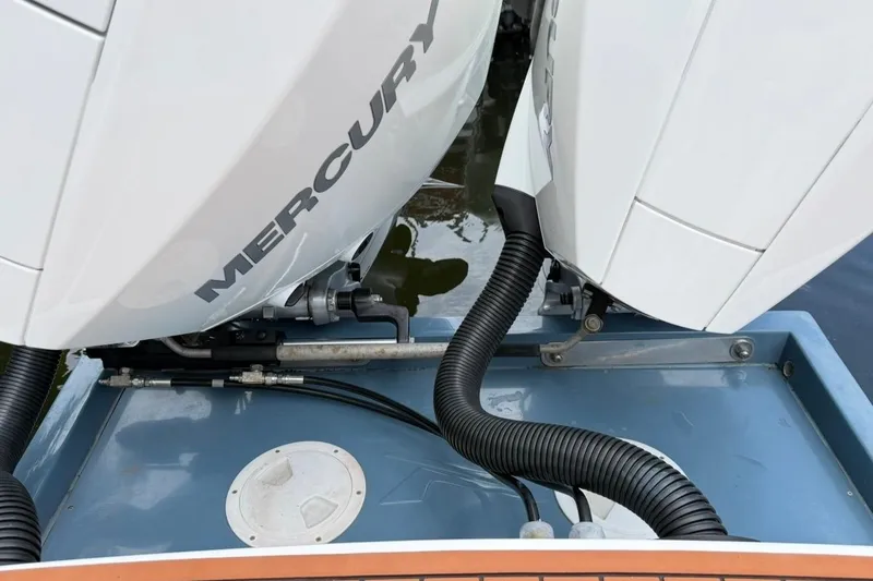 Slide: The Image of Twin Mercury outboard engines on a 2025 NX Boats 340 Sport Coupe, docked on water. - 17