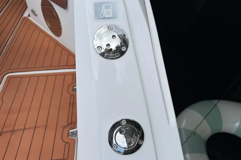 Slide: The Image of Fuel and waste caps on 2025 NX Boats 340 Sport Coupe, featuring teak deck details. - 31