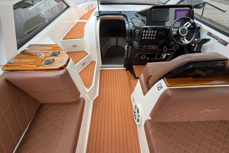 Slide: The Image of Interior of 2025 NX Boats 340 Sport Coupe with luxurious seating and modern dashboard. - 37