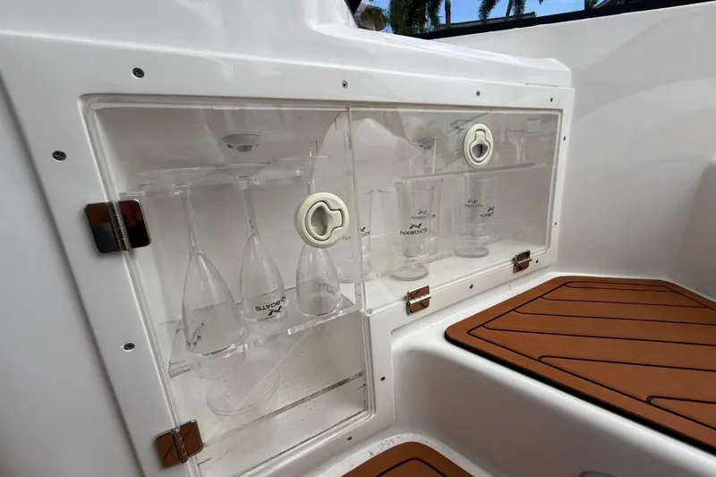 Slide: The Image of 2025 NX Boats 340 Sport Coupe glass storage with wooden flooring detail. - 39