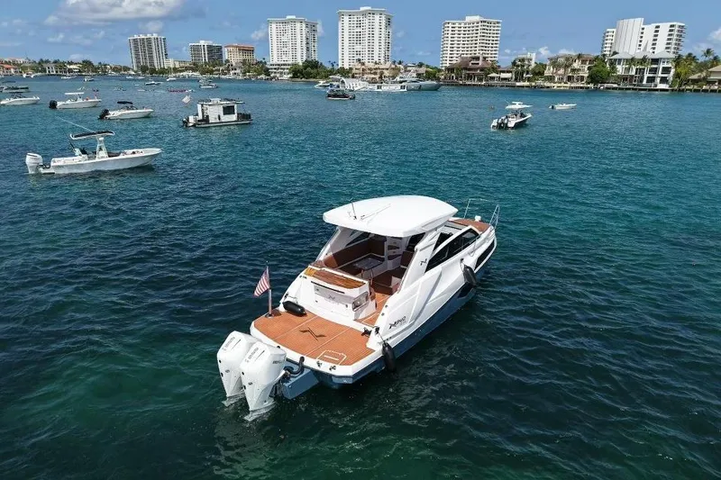 Slide: The Image of 2025 NX Boats 340 Sport Coupe on water, surrounded by other boats and city skyline. - 4