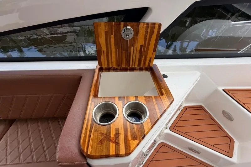 Slide: The Image of Luxury interior of 2025 NX Boats 340 Sport Coupe with wooden accents and cup holders. - 40