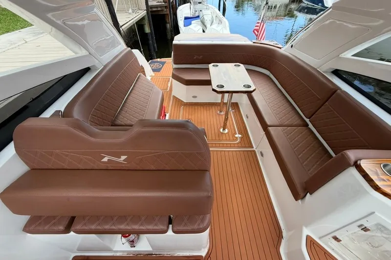 Slide: The Image of Luxurious interior of 2025 NX Boats 340 Sport Coupe with brown leather seating. - 41