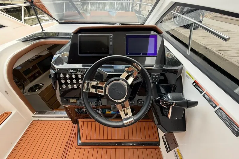 Slide: The Image of Helm of 2025 NX Boats 340 Sport Coupe with modern controls and dual screens. - 42
