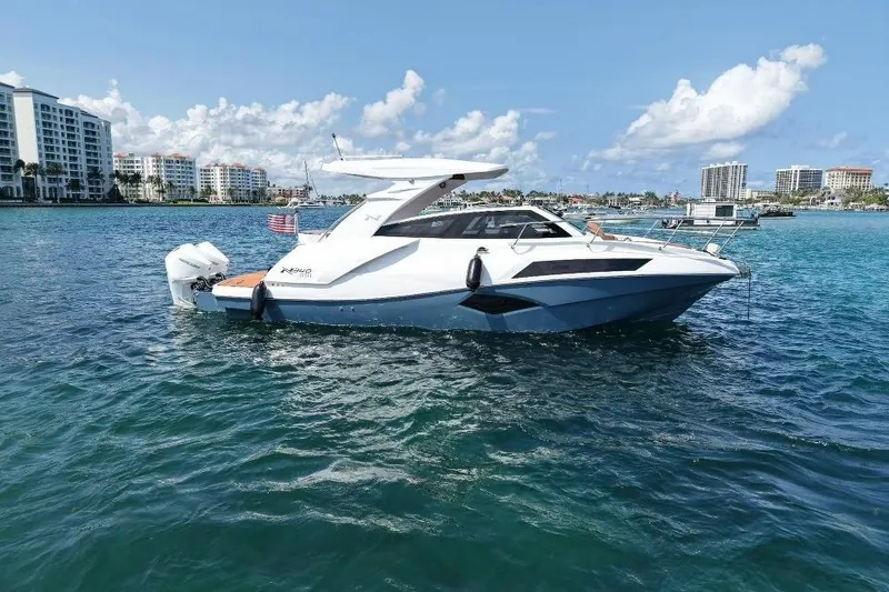Slide: The Image of 2025 NX Boats 340 Sport Coupe on water, with city skyline in background. - 5