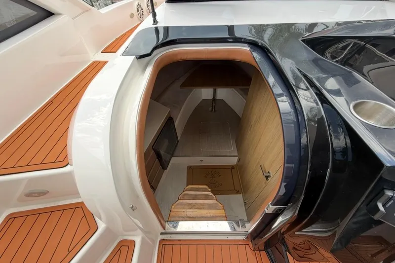 Slide: The Image of Interior view of 2025 NX Boats 340 Sport Coupe cabin entrance with wooden flooring. - 53