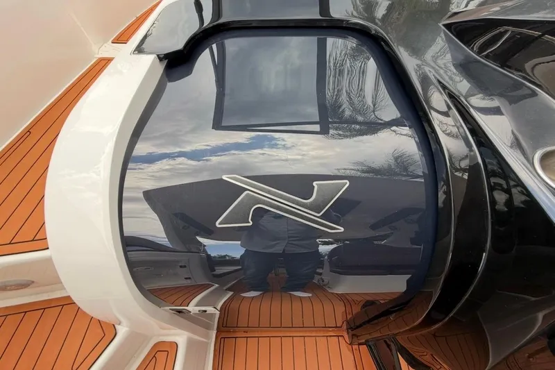 Slide: The Image of 2025 NX Boats 340 Sport Coupe with sleek design and wooden deck. - 54