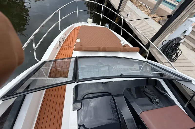 Slide: The Image of 2025 NX Boats 340 Sport Coupe with sleek deck design and luxurious seating. - 56