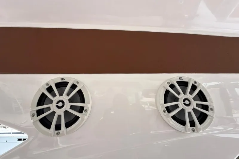 Slide: The Image of 2025 NX Boats 340 Sport Coupe speakers on sleek white and brown exterior. - 64
