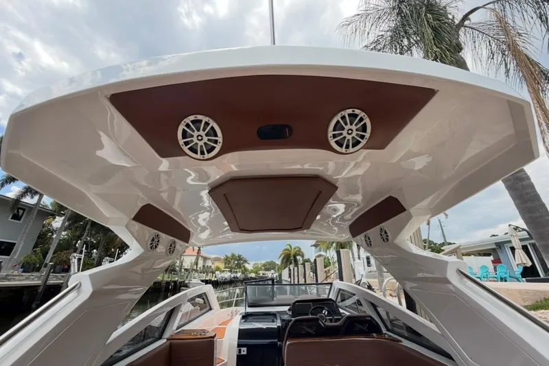 Slide: The Image of 2025 NX Boats 340 Sport Coupe interior with speakers and sleek design. - 65