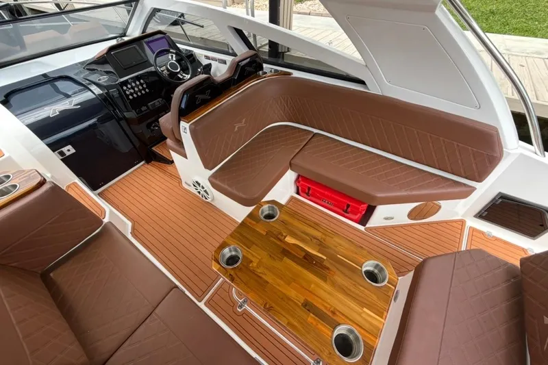 Slide: The Image of Luxurious interior of 2025 NX Boats 340 Sport Coupe with brown leather seating and wood accents. - 66
