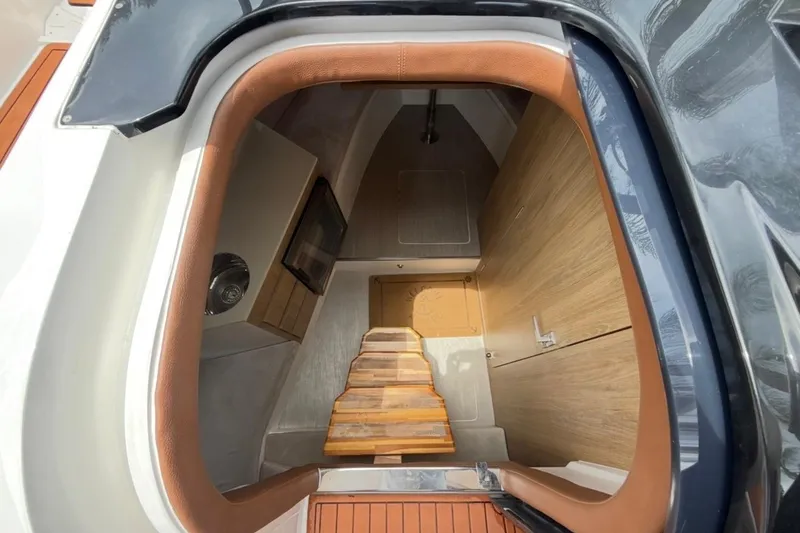 Slide: The Image of Interior view of 2025 NX Boats 340 Sport Coupe cabin with wooden steps and modern design. - 68