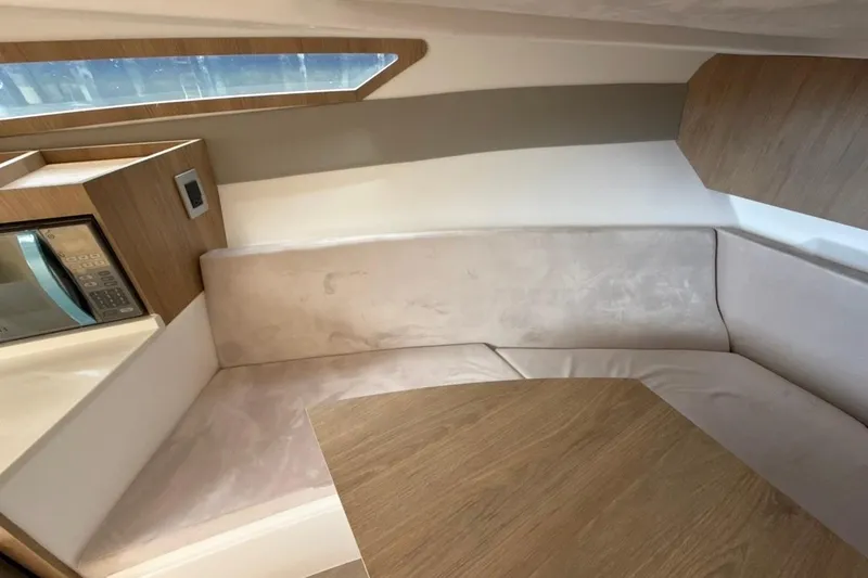 Slide: The Image of Interior of 2025 NX Boats 340 Sport Coupe with modern seating and wooden accents. - 70