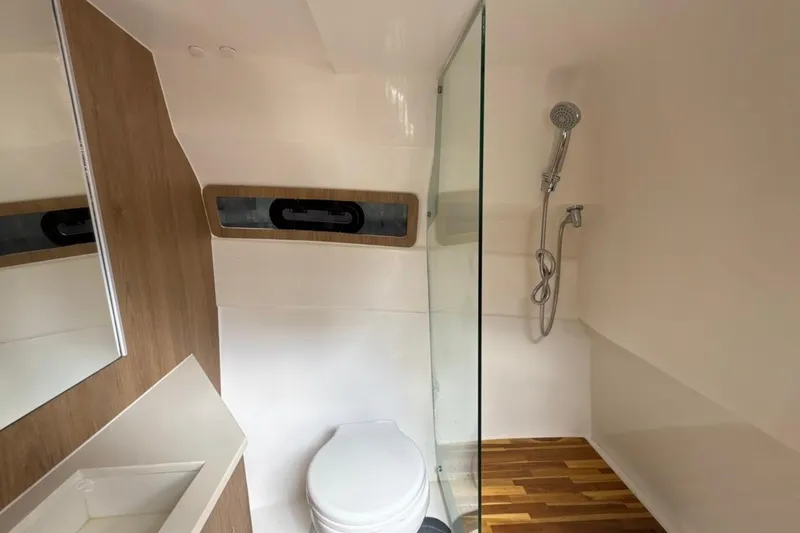 Slide: The Image of Bathroom interior of 2025 NX Boats 340 Sport Coupe with shower and toilet. - 76