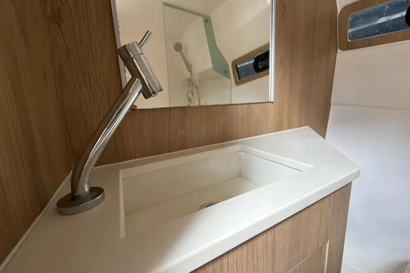 Slide: The Image of Modern bathroom sink in 2025 NX Boats 340 Sport Coupe, featuring sleek faucet and wood accents. - 80