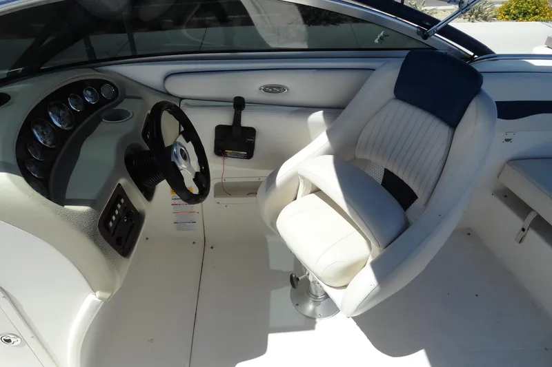 Slide: The Image of 2003 Chaparral 220 SSi boat interior with steering wheel and white captain's chair. - 11