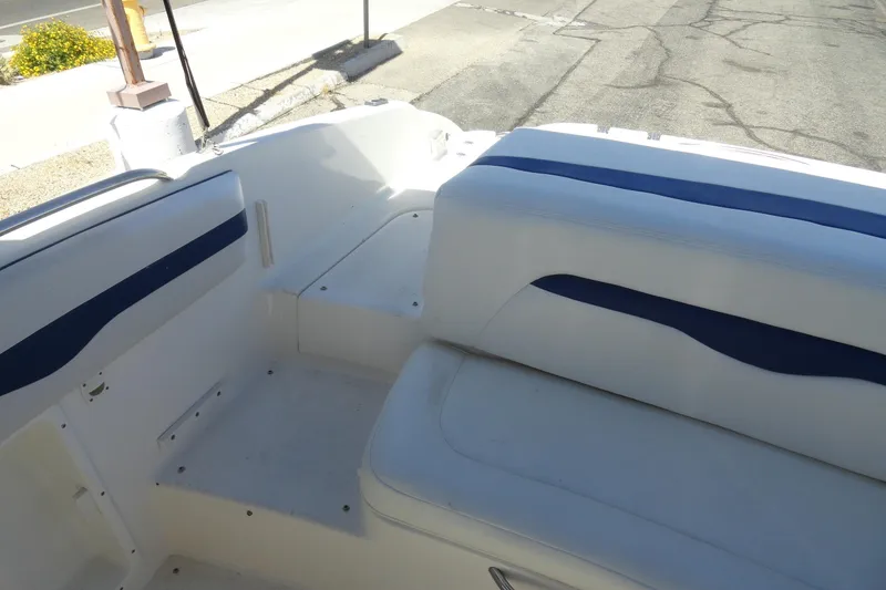 Slide: The Image of Interior seating of a 2003 Chaparral 220 SSi boat, featuring white and blue upholstery. - 16