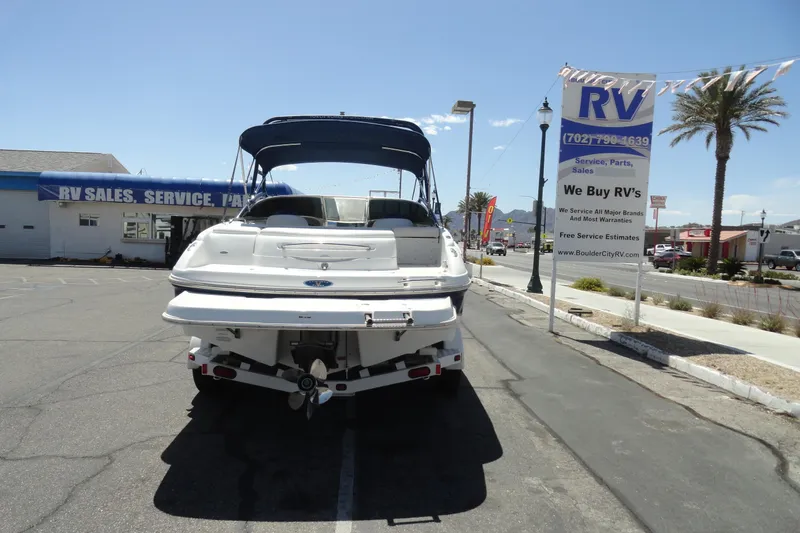 Slide: The Image of 2003 Chaparral 220 SSi boat parked at RV sales lot under clear sky. - 20