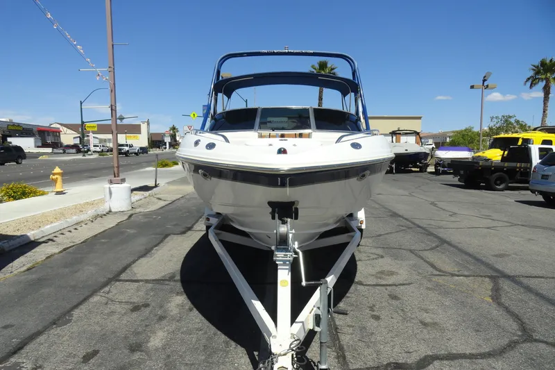 Slide: The Image of 2003 Chaparral 220 SSi boat on trailer, parked on urban street under clear blue sky. - 3