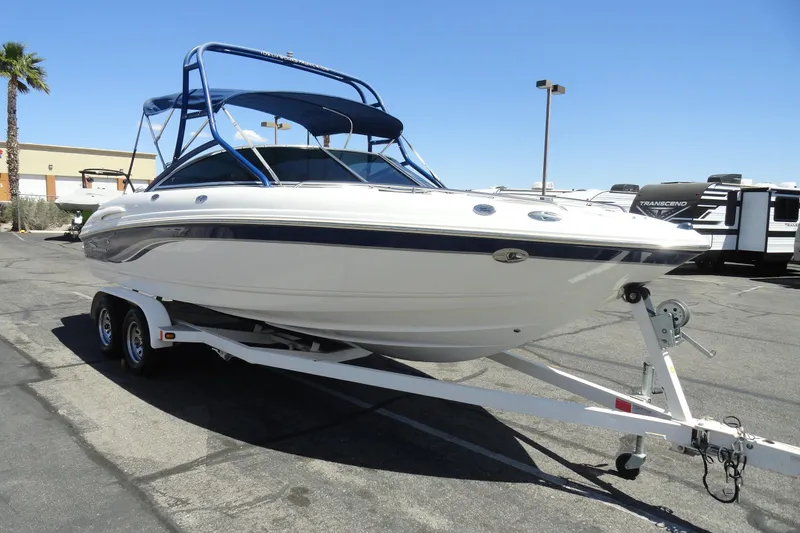 Slide: The Image of 2003 Chaparral 220 SSi boat on trailer, parked outdoors under clear blue sky. - 4