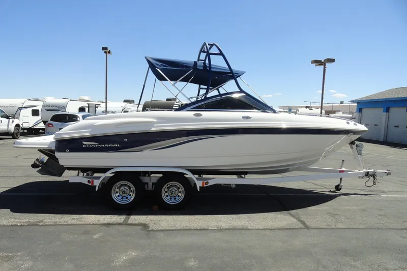 Slide: The Image of 2003 Chaparral 220 SSi boat on trailer, parked outdoors under clear blue sky. - 5