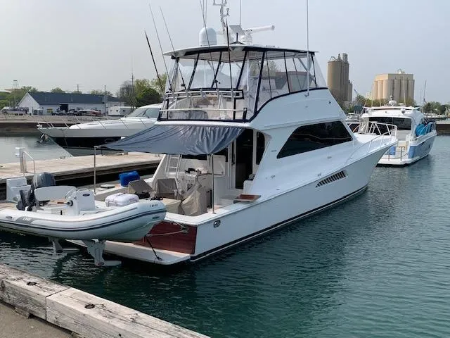 Slide: The Image of 2002 Viking 55 Convertible yacht docked with inflatable boat attached. - 10