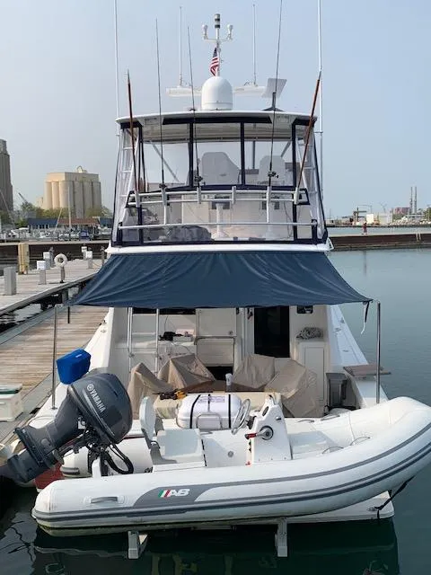 Slide: The Image of 2002 Viking 55 Convertible yacht docked with inflatable boat attached. - 11