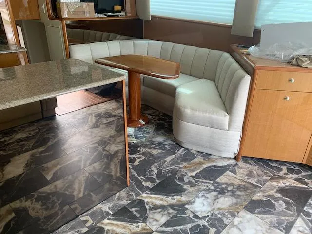 Slide: The Image of Interior of 2002 Viking 55 Convertible yacht with marble flooring and cushioned seating. - 18