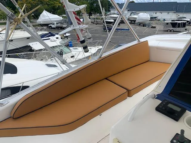 Slide: The Image of 2002 Viking 55 Convertible yacht with tan seating on deck, docked at marina. - 20