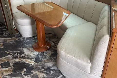 Slide: The Image of 2002 Viking 55 Convertible interior with beige seating and wooden table on marble-patterned floor. - 33