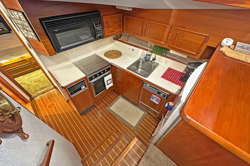 Slide: The Image of 1988 Ocean Yachts 48 Super Sport kitchen with wood cabinetry and modern appliances. - 17