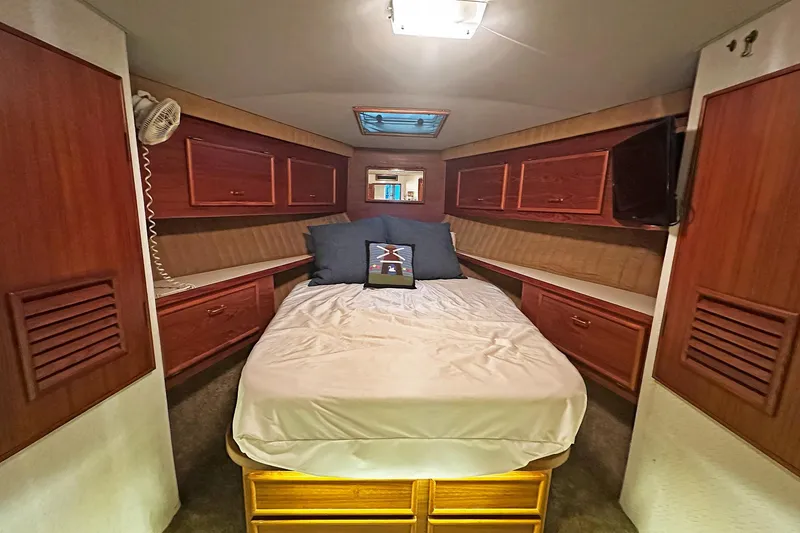 Slide: The Image of Luxurious cabin interior of 1988 Ocean Yachts 48 Super Sport with cozy bed and wooden cabinetry. - 26