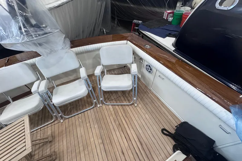 Slide: The Image of 1988 Ocean Yachts 48 Super Sport deck with white chairs and wooden flooring. - 37