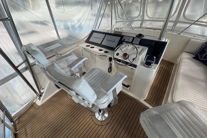 Slide: The Image of 1988 Ocean Yachts 48 Super Sport helm with Garmin navigation, white seating, and teak flooring. - 39