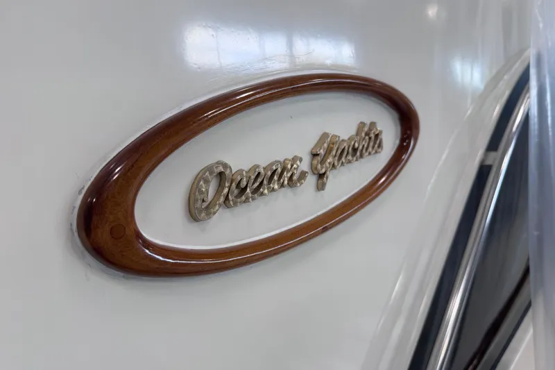 Slide: The Image of Ocean Yachts 48 Super Sport 1988 emblem on yacht exterior, featuring elegant wood trim. - 46