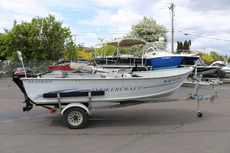 The Image of 2004 Smoker Craft Alaskan 15 boat on trailer in outdoor setting. - 0