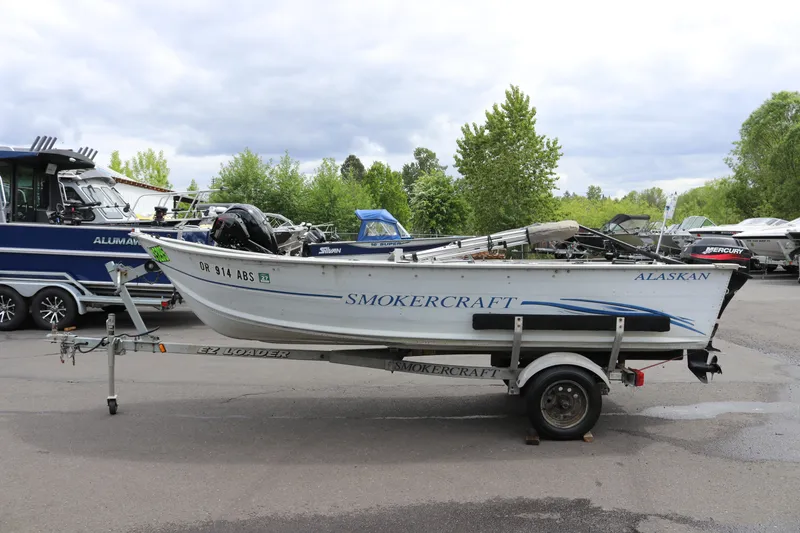 Slide: The Image of 2004 Smoker Craft Alaskan 15 boat on trailer, parked outdoors. - 2