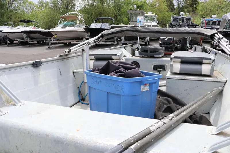 Slide: The Image of 2004 Smoker Craft Alaskan 15 boat interior with blue storage bin and equipment. - 3