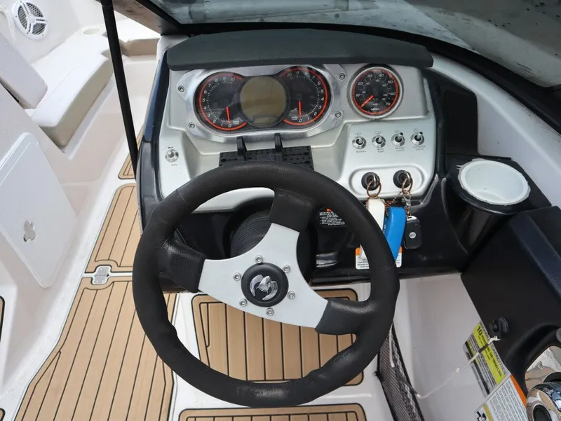 Slide: The Image of Steering wheel and dashboard of a 2014 Scarab 215 boat. - 12
