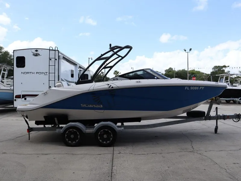 Slide: The Image of 2014 Scarab 215 boat on trailer outdoors. - 5