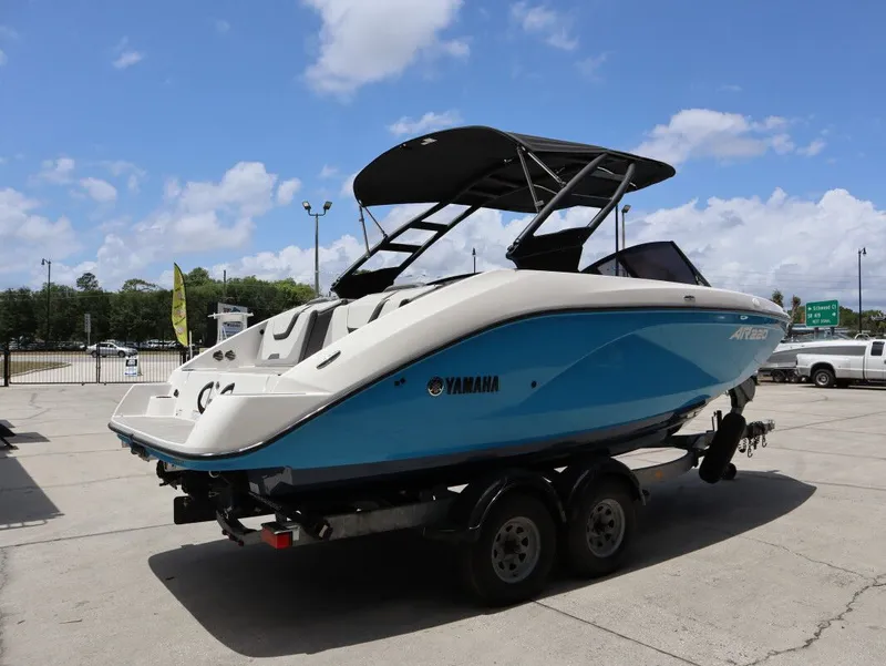 Slide: The Image of 2023 Yamaha AR220 boat on trailer under blue sky. - 6