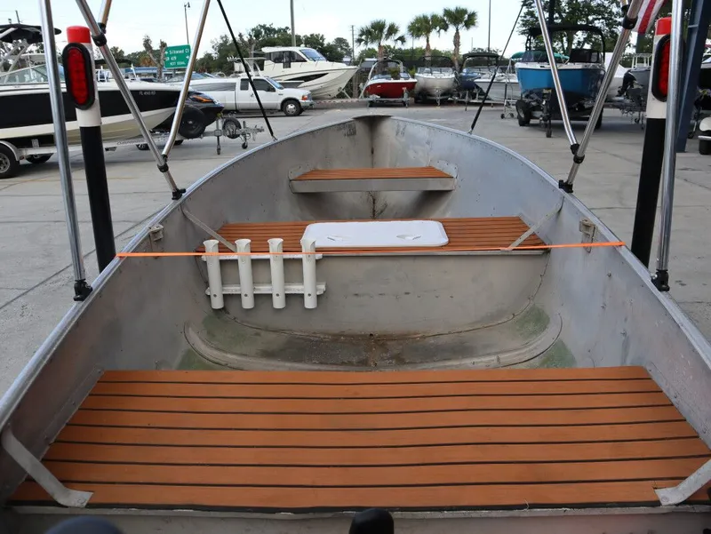 Slide: The Image of 1953 TDCM 16' Utility Fish Boat with wooden benches at the dock. - 11