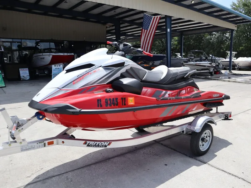 Slide: The Image of 2025 Yamaha GP 1900 HO jet ski on trailer, red and white, outdoors. - 3